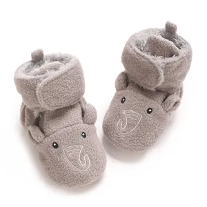 Gros plan de bottes bébé en peluche grise avec broderie éléphant et doublure