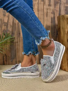 Macro detail showing shiny silver glitter loafers with stylish bow and platform soles