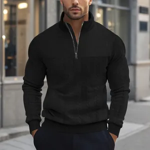 Detailopname van een zwart herensweatshirt met kwartrits en ingewikkelde jacquard breipatronen.