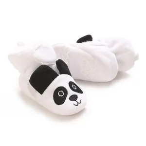 Gros plan de bottines souples en peluche blanche pour bébé avec motif panda brodé