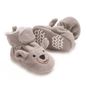 Vue détaillée des chaussons bébé ours gris en polaire douce avec semelles antidérapantes.
