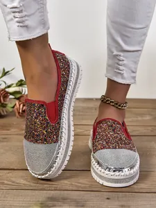 Primer plano de mocasines con purpurina multicolor, punta de pedrería y suela blanca gruesa.