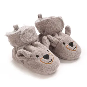 Gros plan de bottines pour bébé grises avec visage d'ours et polaire