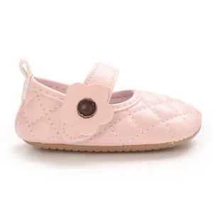 Gros plan sur une petite chaussure de bébé en cuir PU rose matelassé avec détail fleur