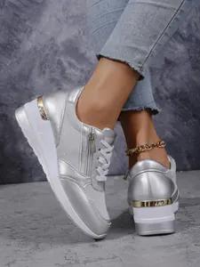 Detailansicht silberner Metallic-Keil-Sneaker für Damen mit dicken weißen Sohlen.