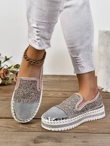 Detalle de mocasines con pedrería brillante para mujer con suela de plataforma blanca.