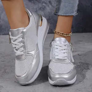 Modische silberne Damen-Sneaker mit Keilabsatz in einer detaillierten Trageansicht