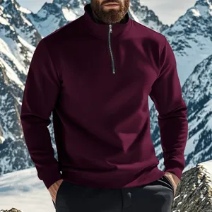 Gros plan d'un sweat-shirt bordeaux à quart de zip pour homme dans un décor de neige