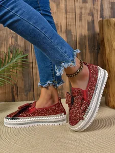 Detailed view of women's red sequined flat shoes featuring a stylish bow and platform sole