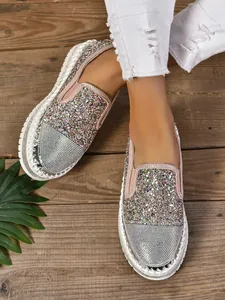 Primer plano de mocasines brillantes con pedrería para mujer y suelas blancas