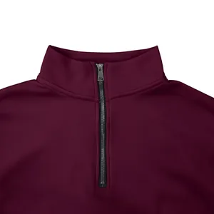 Gros plan sur la fermeture éclair et le col montant d'un sweat-shirt en polaire bordeaux.