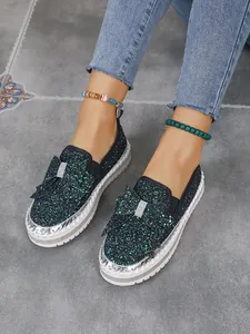 Detailed view of women's sequin flat shoes with sparkling bow embellishment