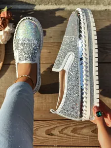 Vista detallada de mocasines con plataforma de diamantes de imitación plateados y purpurina.