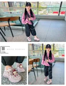 Detailed view of girls pink winter sneakers with cute cartoon charms and plush lining
