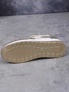 Nahaufnahme der rutschfesten goldfarbenen Profilsohle dieser Damen-Plateauschuhe.