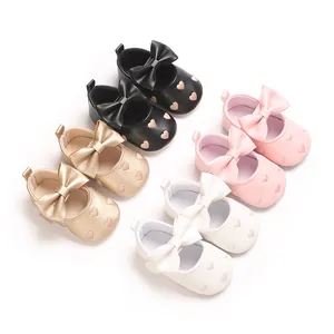 Sélection de chaussures pour bébés avec broderies de cœurs et nœuds papillon chic.