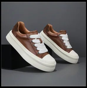Side view of brown leather platform sneakers with chunky soles and wide white laces
