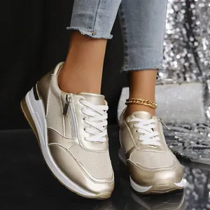 Detailansicht der champagnergoldenen Plateau-Sneaker am Fuß mit Pailletten-Hintergrund