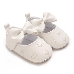 Vue détaillée des chaussures bébé princesse blanches avec cœurs brodés et nœud