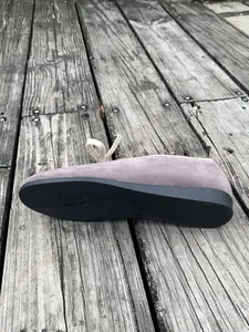 Detailweergave van paarse suède loafers met antislip rubberen zool