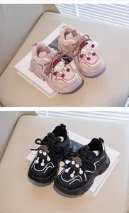 Close-up of pink and black winter sneakers for kids with fleece lining and cartoon sheep
