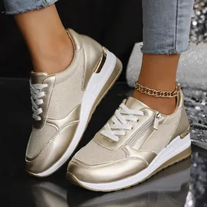 Detailansicht goldener Keilsneaker für Damen mit modischem Reißverschluss und Schnürung