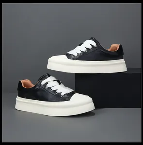 Detail view of black leather platform sneakers with wide white laces and thick sole