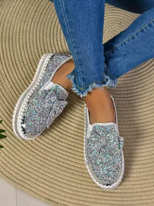 Detailed view of women's sparkling sequined flat shoes with a large decorative bow.