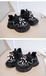 Close-up of children's black winter sneakers with plush lining and cute cartoon character detail