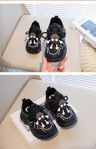 Close-up of black cartoon kids sneakers with warm fleece lining and soot sprite character charm.