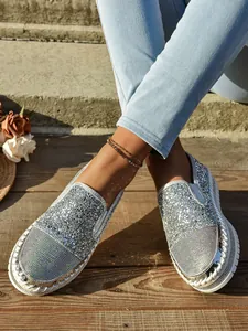 Vista detallada de mocasines de strass plateados brillantes con suela de plataforma