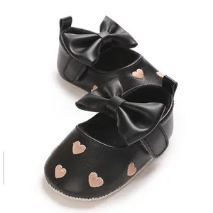 Détail de chaussures Mary Jane bébé noires avec cœurs brodés et nœuds