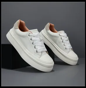 Side view of white leather platform sneakers with trendy wide laces and thick soles