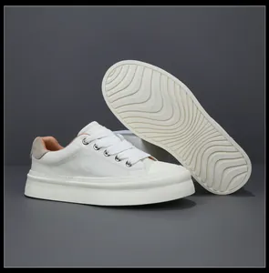 Detailed view of white leather platform sneaker with wave-patterned non-slip sole