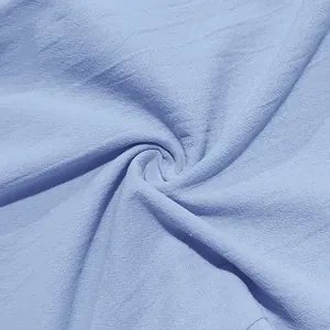 Dettaglio macro del tessuto in lino azzurro traspirante per pantaloni casual da uomo.