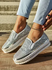 Detalle de zapatos de plataforma con pedrería plateada para mujer estilo otoñal