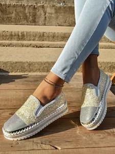 Detalle de mocasines con plataforma y pedrería para mujer en plata y oro