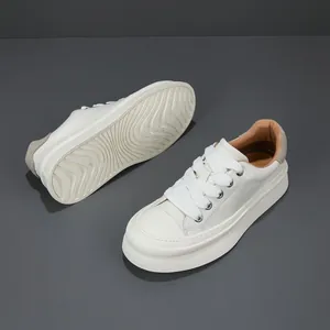 White men's leather sneakers with thick soles and wide laces in a minimalist studio