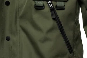 Macro view of olive green tactical jacket showing durable fabric and zipper pocket detail