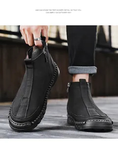 Vue détaillée des bottines en cuir noir pour hommes avec fermeture éclair et coutures