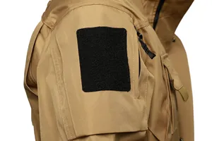 Detailed close-up of tactical jacket sleeve featuring black Velcro patch and pocket zipper