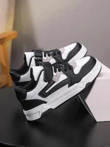 Vista de detalle de las zapatillas casuales para niño en blanco y negro con correa