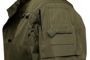 Detailed close-up of a green tactical jacket sleeve showing durable fabric and pocket.
