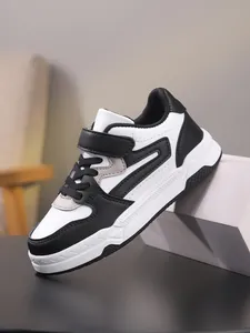 Primer plano de zapatillas casuales de cuero en blanco y negro para niños con velcro