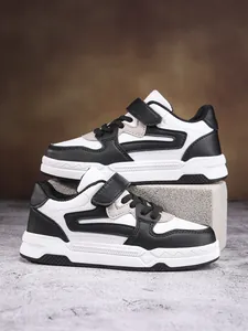 Detalle de zapatillas deportivas blancas y negras para niños con velcro