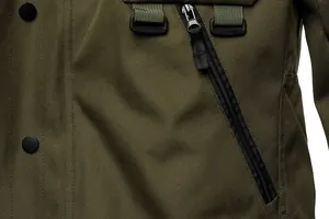 Close-up view of olive green tactical jacket featuring heavy-duty canvas fabric and zipper