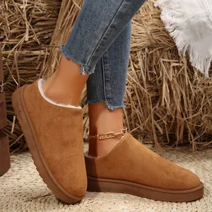 Detailed view of women's tan suede snow boots with thick soles and cozy faux fur lining