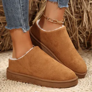 Close-up of brown suede women's snow boots with white fur lining and thick sole.