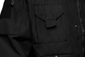 Macro detail of black tactical jacket showing windproof fabric texture and pocket.