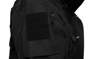 Close-up of black tactical jacket arm showing durable velcro patch area and zipper pocket